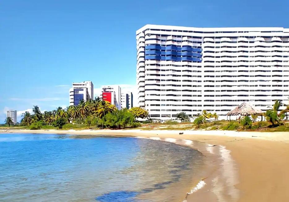 a beach with a large building in the background at Esparta Suite isla de margarita in Porlamar