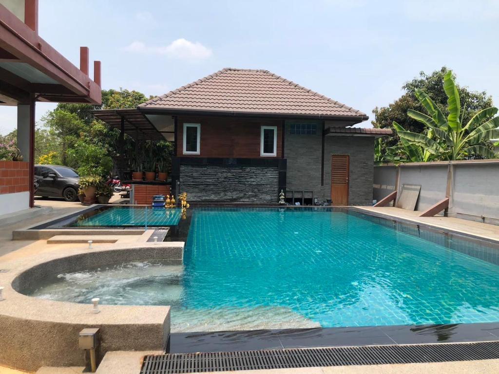 a swimming pool in front of a house at Rabbit House แรบบิท เฮ้าส์ in Ban Han Tra Fang Nua
