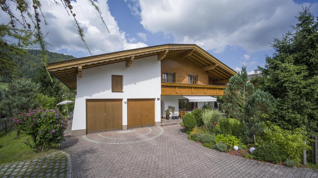 een huis met een gambrel dak en een garage bij Haus Kurz - Kurz Nadine in Walchsee