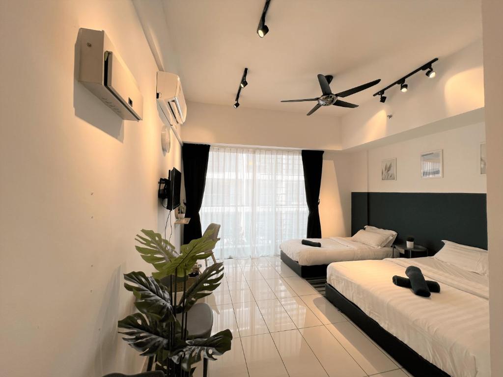 a bedroom with two beds and a ceiling fan at KASOTA SUITE Aeropod Sovo-Near KKCity-Near Airport in Tanjong Aru