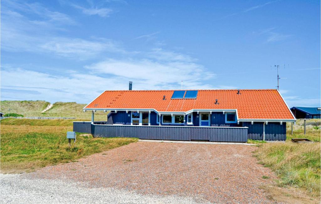 una casa con un tetto arancione su una strada sterrata di Lovely Home In Thisted With Indoor Swimming Pool a Klitmøller