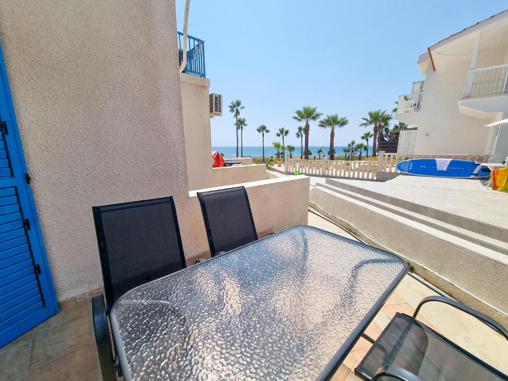 einen Tisch und Stühle auf einem Balkon mit Meerblick in der Unterkunft Beach Vibes Apartment in Pyla