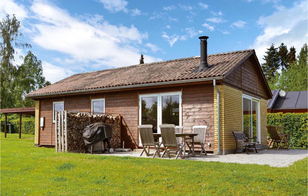 Cette petite maison dispose d'une terrasse et d'un barbecue. dans l'établissement Cozy Home In Kirke Hyllinge With Kitchen, à Sæby