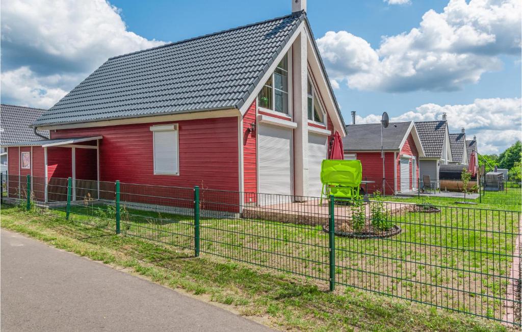 a red house with a green fence in front of it at 2 Bedroom Stunning Home In Zerpenschleuse in Berg