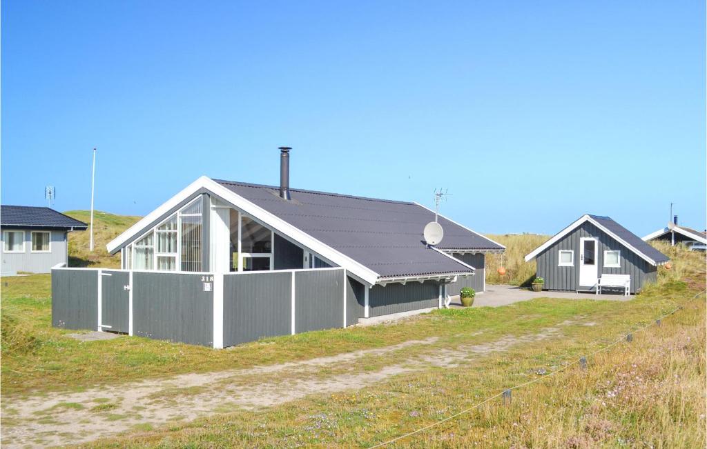 Bjerregårdにある2 Bedroom Nice Home In Hvide Sandeの前に柵のある家