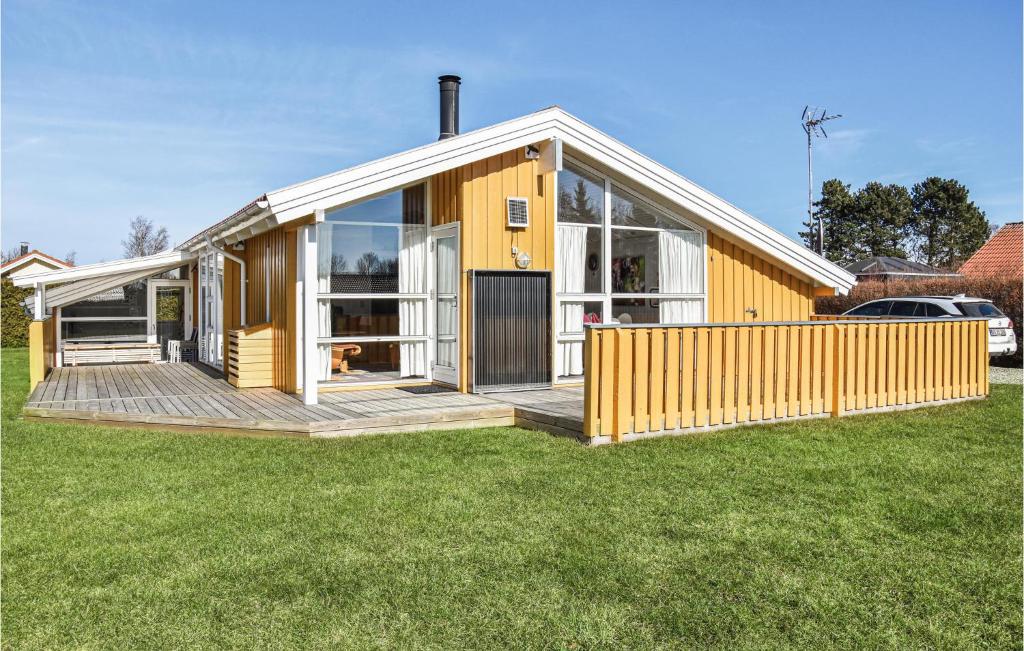 オテルプにあるAwesome Home In Otterup With 4 Bedrooms, Sauna And Wifiの芝生の木製デッキ付きの家
