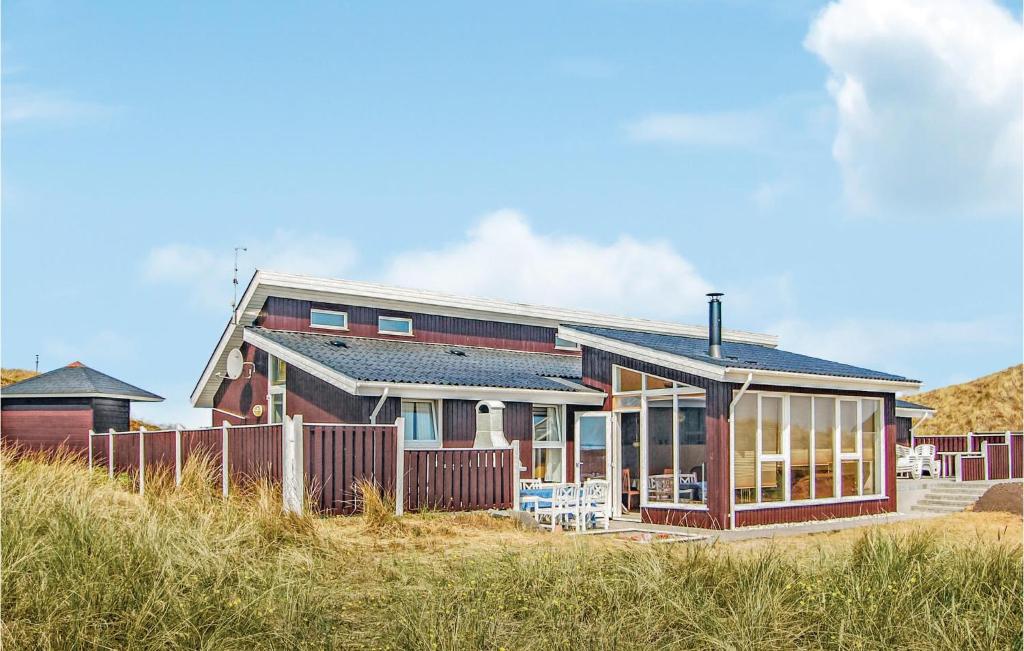 a house on top of a beach with a fence at 4 Bedroom Gorgeous Home In Hvide Sande in Havrvig