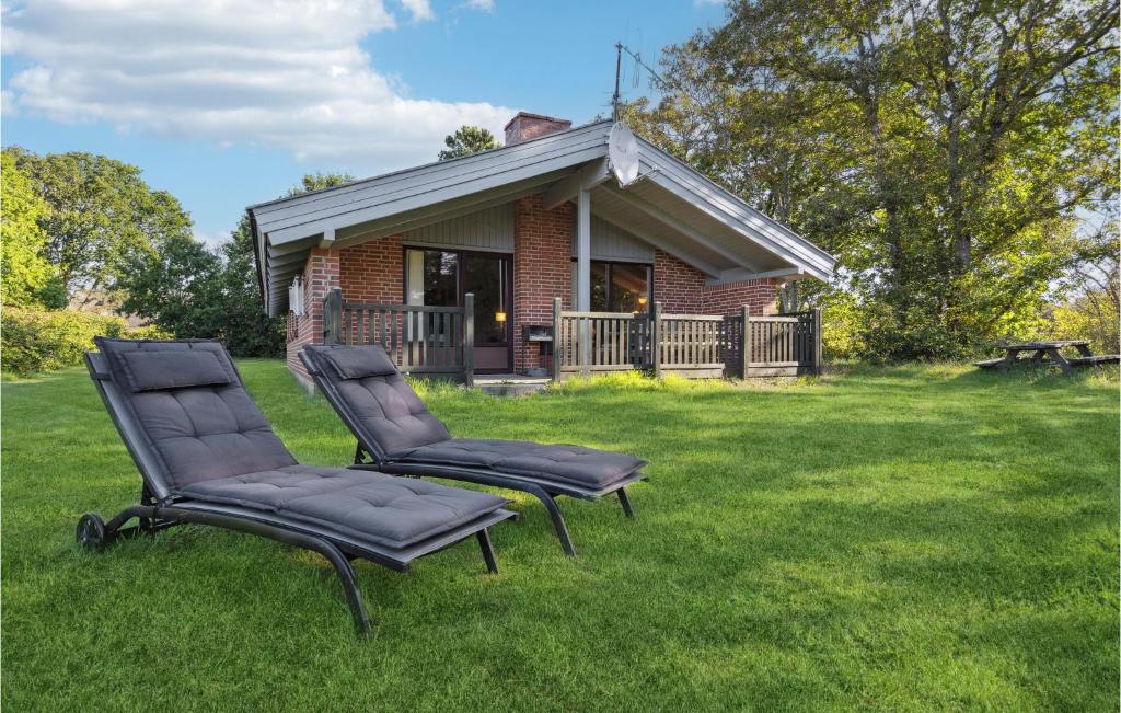 ヘンネ・ストランドにあるAwesome Home In Henne With 3 Bedrooms And Saunaの家の前の芝生に座る椅子2脚