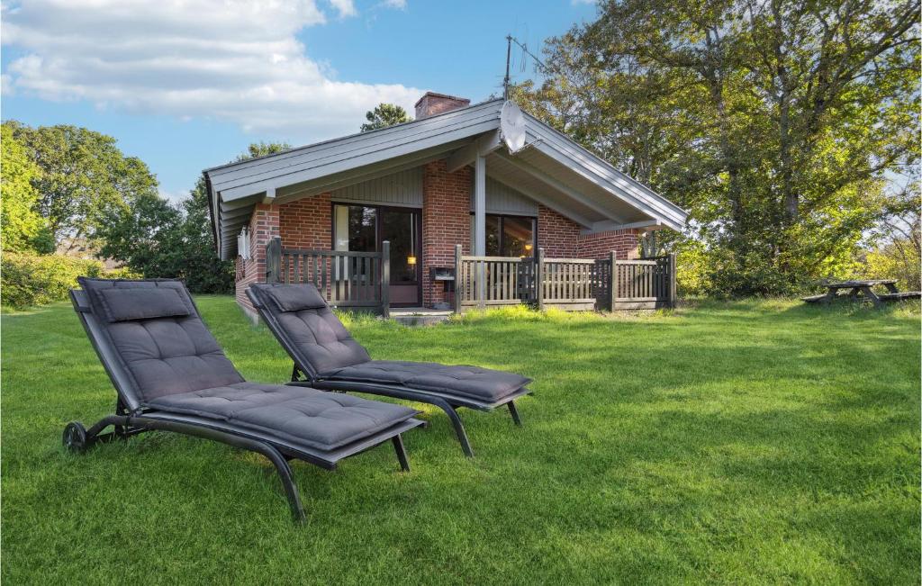 two chairs sitting in the grass in front of a house at Awesome Home In Henne With 3 Bedrooms And Sauna in Henne Strand