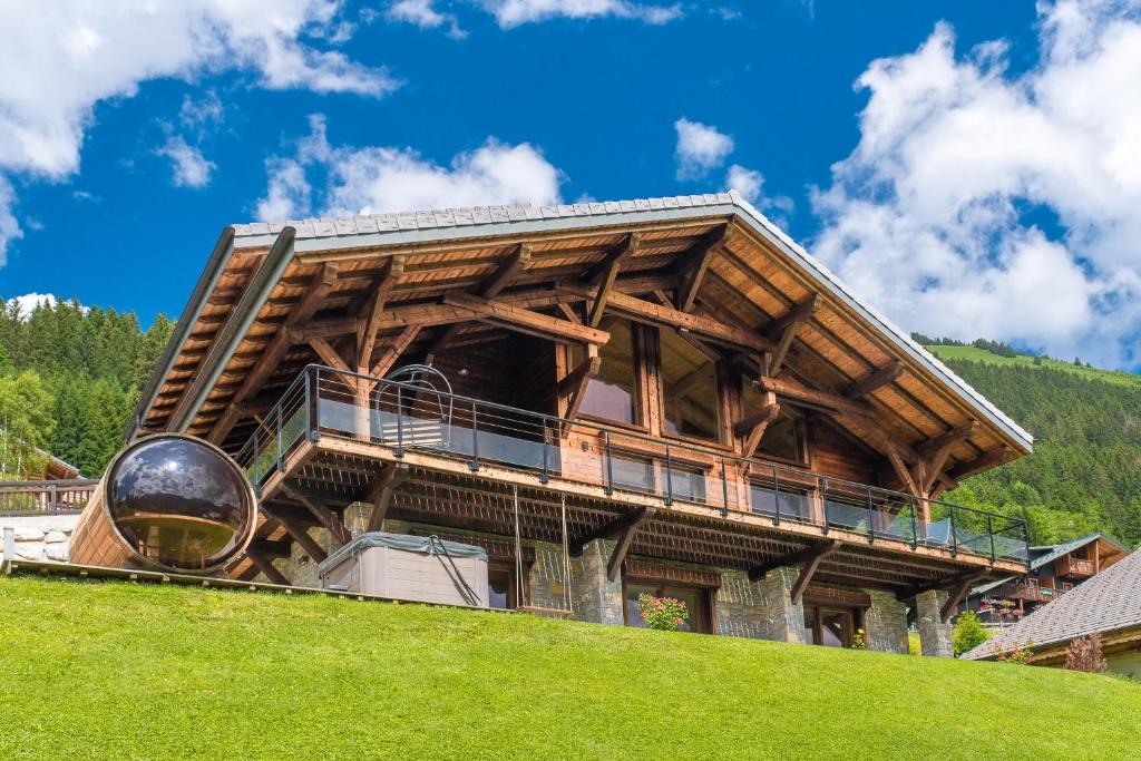a large wooden building on top of a hill at Chalet Familial Le Whymper 5 étoiles SPA Sauna Chatel in Châtel