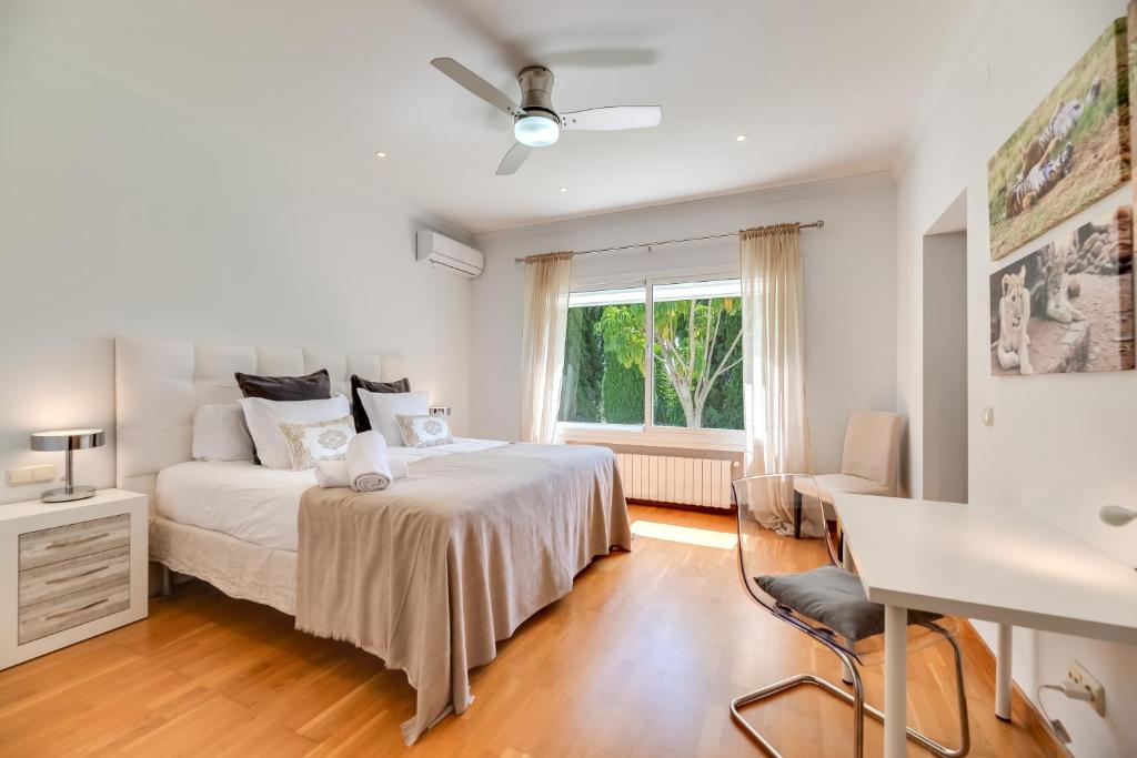 a bedroom with a bed and a desk and a window at VACATION MARBELLA I Villa Ballesteros, Near Golf Courses, Private Pool and Gigantic Garden in Estepona