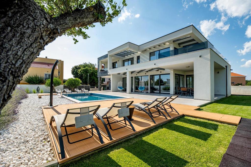 een villa met een zwembad en een gazon bij Villa Barako Prestige - 4 Bedroom Villa - Very Modern Interior - WiFi and Air Conditioning in Nin