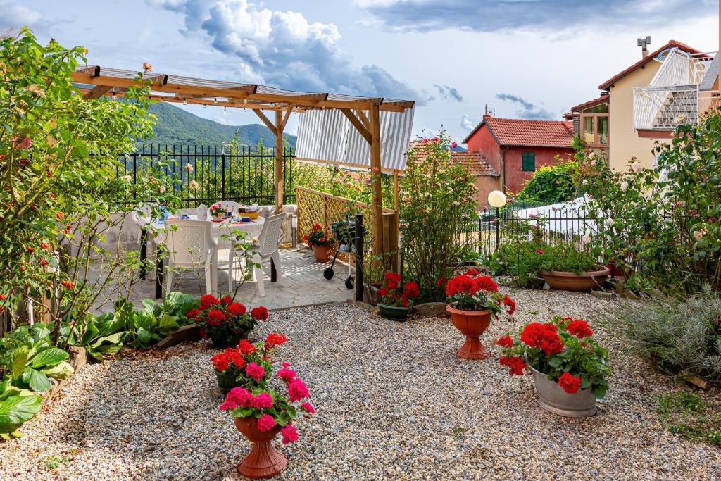 einen Garten mit einem Tisch und Blumen in Töpfen in der Unterkunft casetta della fontana in Serra Rocco