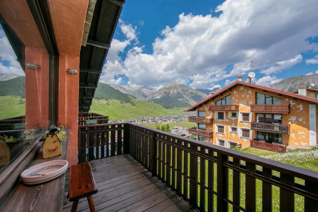 a balcony with a view of a building and mountains at Arianna - Happy Rentals in Livigno