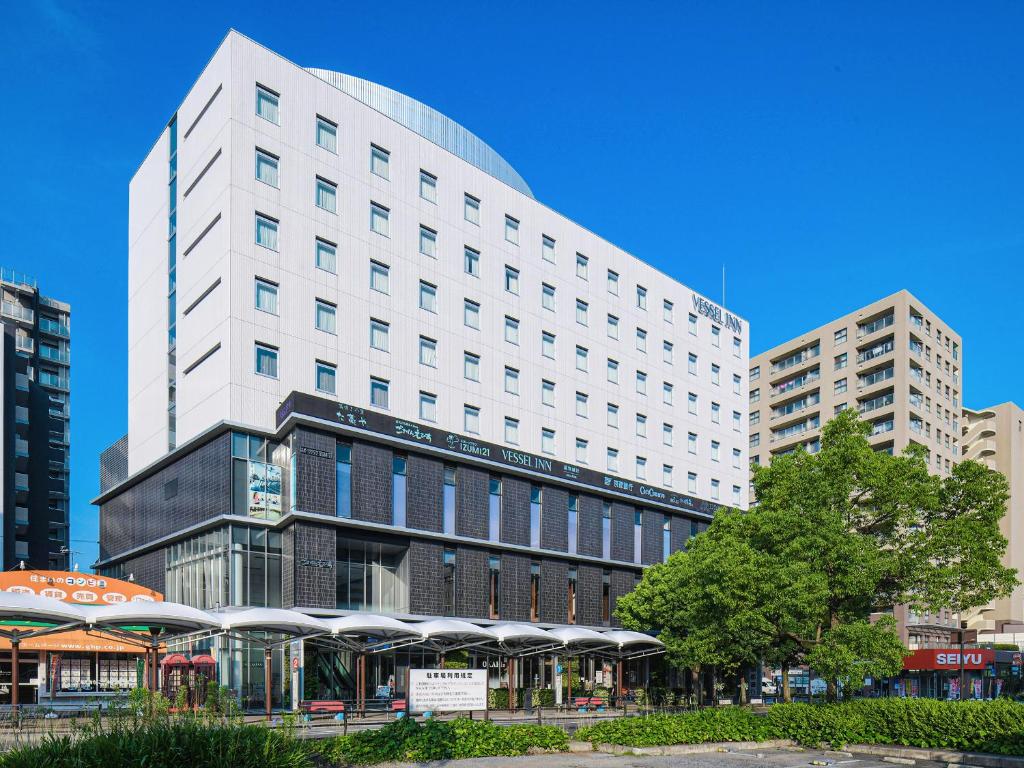 守山的住宿－Vessel Inn Shigamoriyamaekimae，一座位于城市中心的白色大建筑