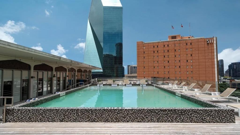 uma piscina no telhado de um edifício com uma cidade em Bold CozySuites with pool, gym, roof #8 em Dallas