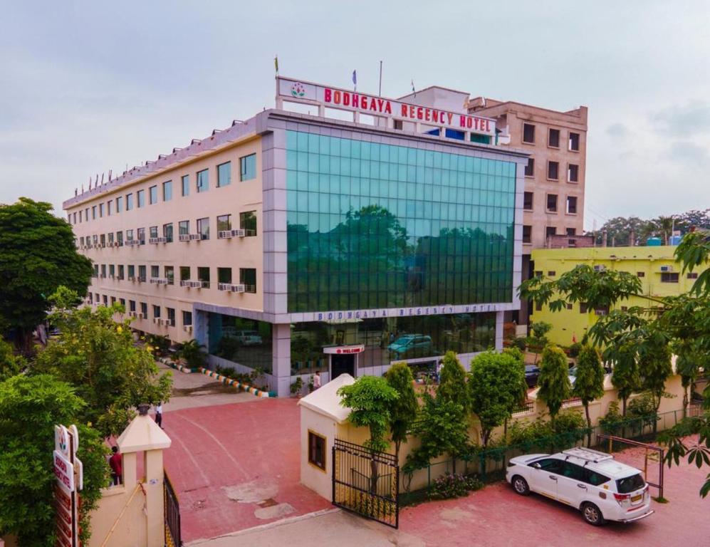 ein Gebäude mit einem davor geparkt in der Unterkunft Bodhgaya Regency Hotel in Bodh Gaya