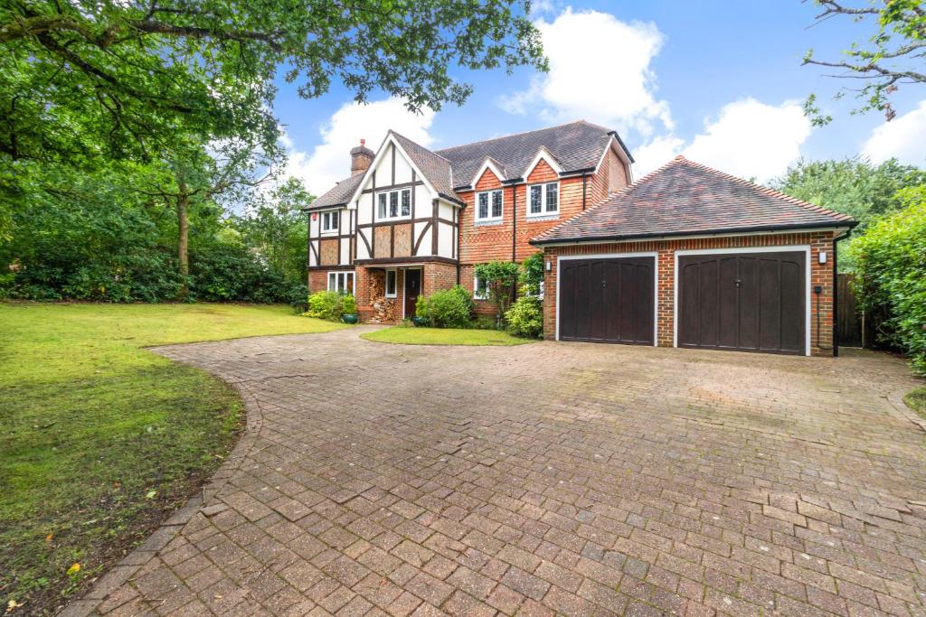 a large brick house with a garage at Pass the Keys Ashdown Forest retreat a spacious stylish house in Crowborough