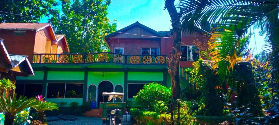 una casa de color verde y rojo en Akarshan Bono Bunglow, en Lataguri