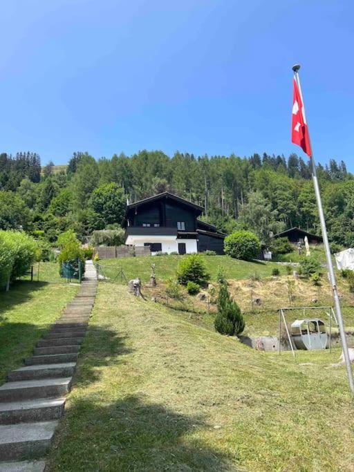 a house on a hill with a flag in the grass at Chalet du Moléson in Gruyères