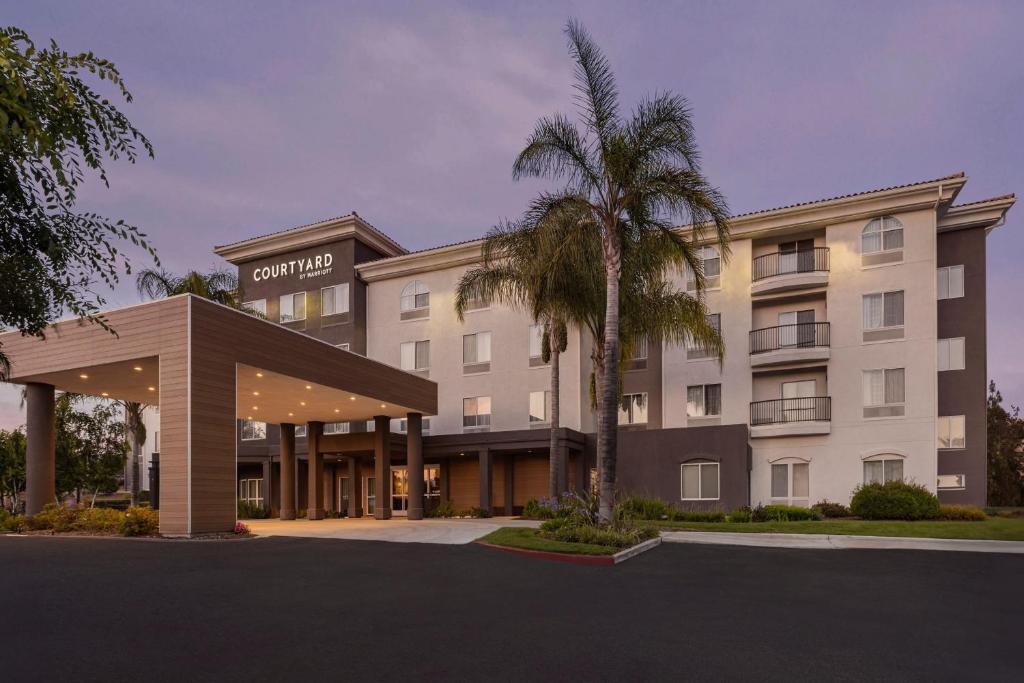 a hotel with a palm tree in front of a building at Courtyard Ventura Simi Valley in Simi Valley