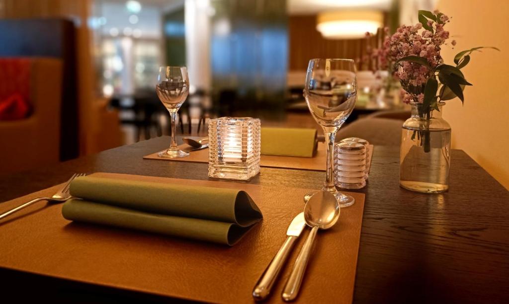 a wooden table with a napkin and silverware on it at Heide Spa Hotel &amp; Resort in Bad Düben