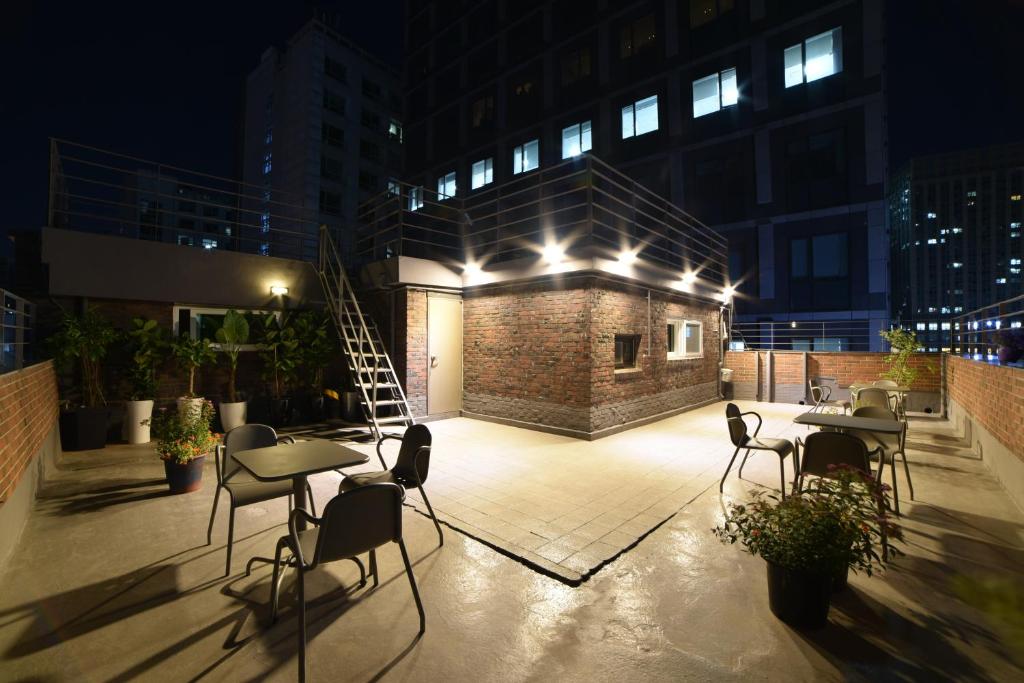 a rooftop patio with tables and chairs at night at Soosong Guesthouse in Seoul