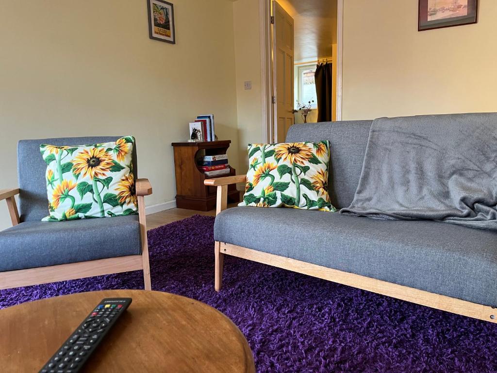 a living room with two couches and a table at The Annex in Ottery Saint Mary