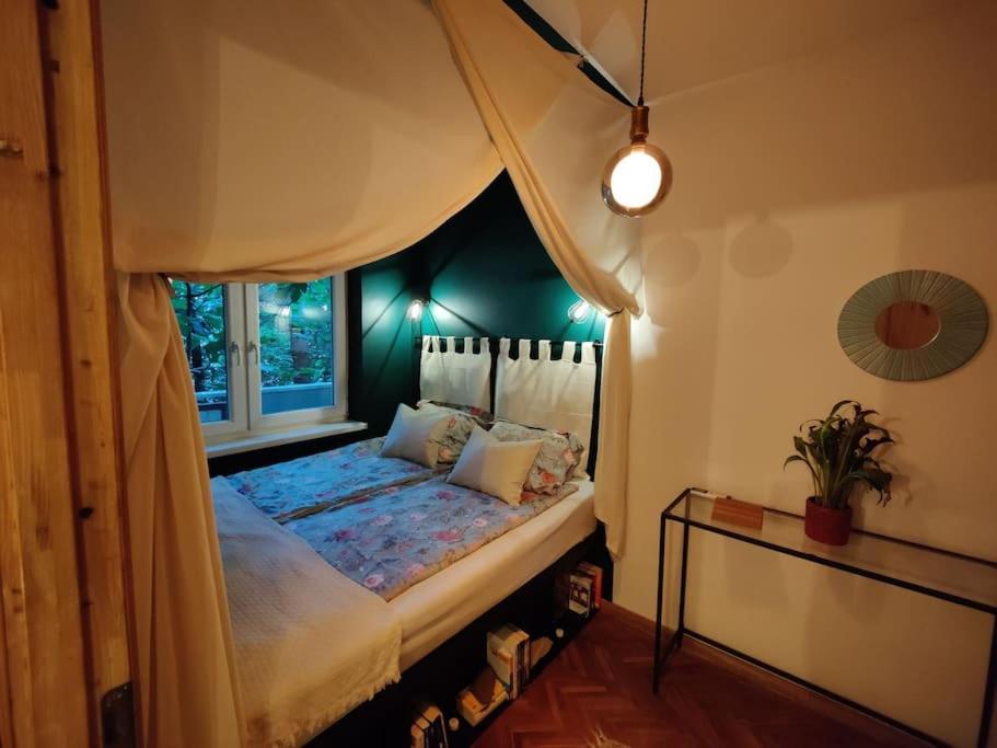 1 dormitorio con cama con dosel y ventana en Nookbed en Budapest