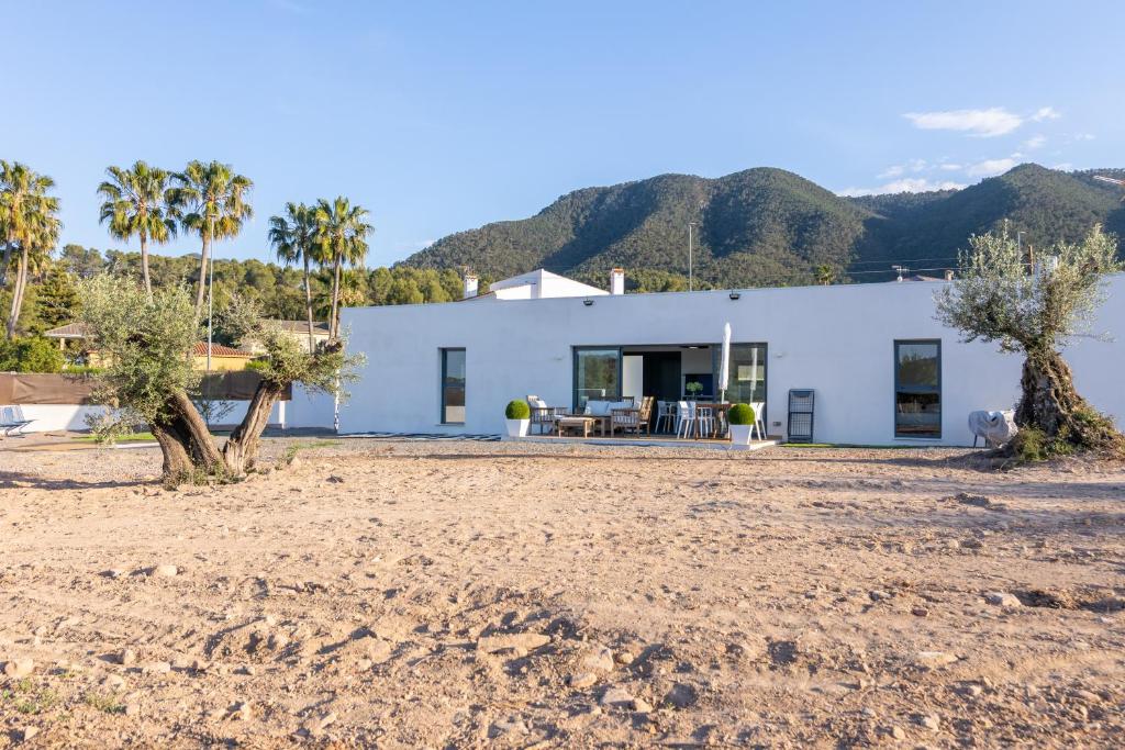 a white house with palm trees in front of it at Casa Rural Espadan Suites in Artana