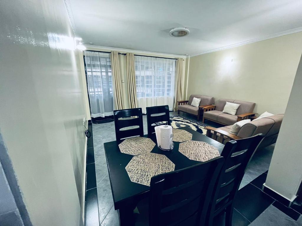 ein Esszimmer mit einem Tisch und Stühlen sowie ein Wohnzimmer in der Unterkunft Idyllic Sojourn in Nakuru