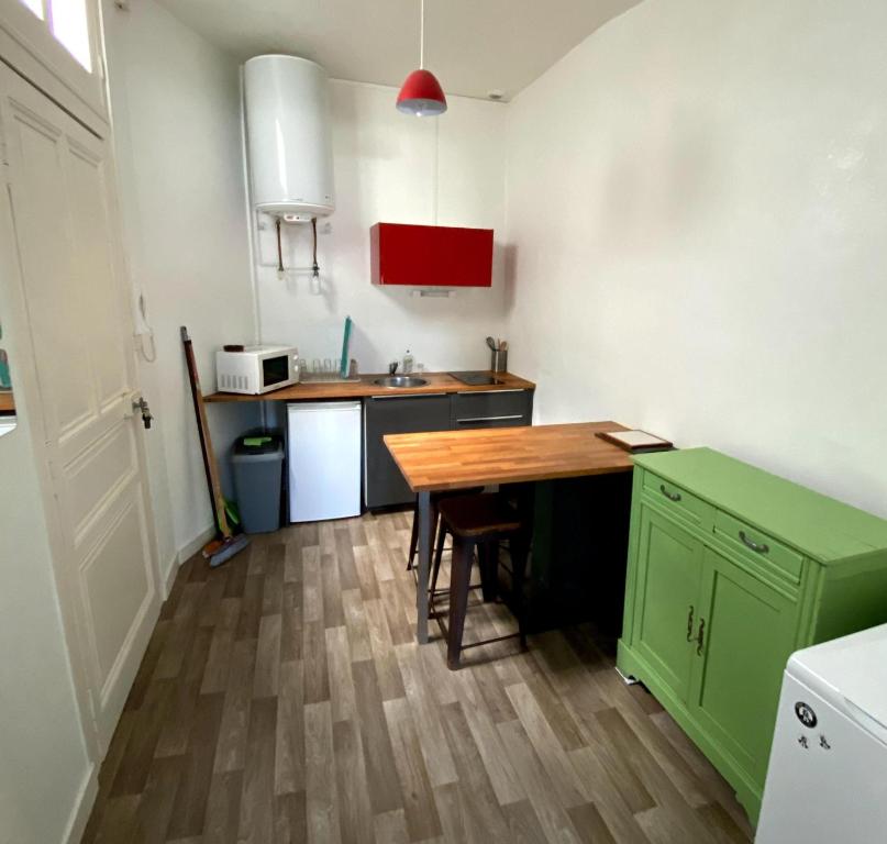 a kitchen with a wooden table and a wooden floor at Studio hypercentre ralliement in Angers