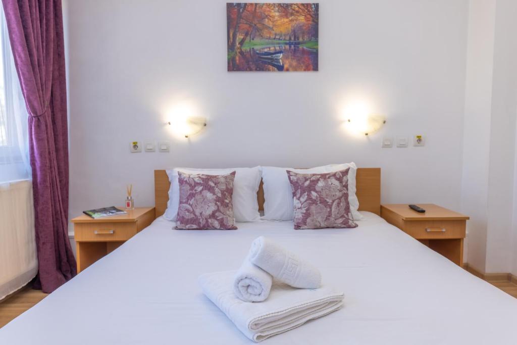 een slaapkamer met een wit bed en handdoeken bij Hotel Sir Gara de Nord in Boekarest