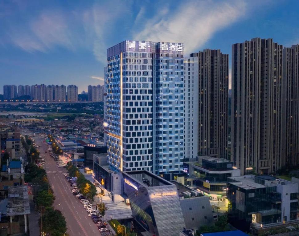 een hoog gebouw midden in een stad bij Beauty Ripples Hotel, South High -speed Railway Station in Changsha