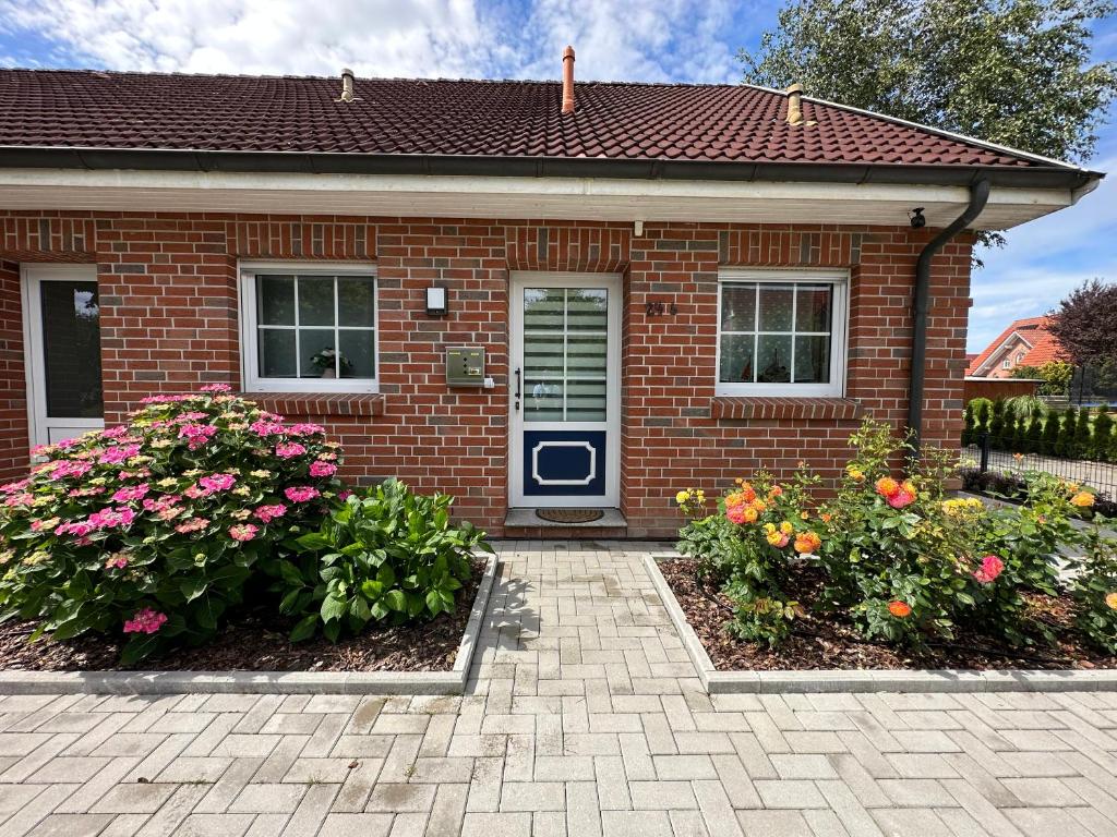 a brick house with flowers in front of it at Ferienwohnung Nordseemond in Norden