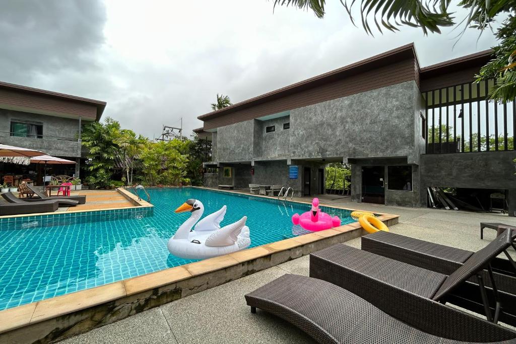 ein Pool mit aufblasbaren Enten und Schwänen in der Unterkunft Tann Anda Resort in Thalang