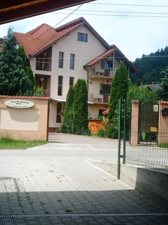 a white house with a fence and a building at Casa de Vacanta Eva in Stoeneşti