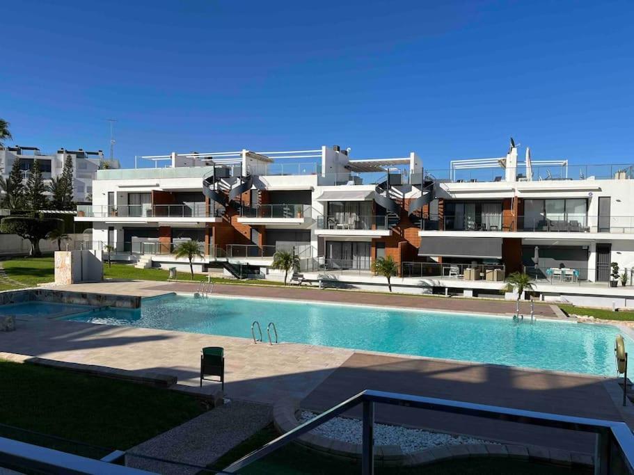 a large building with a swimming pool in front of a building at Appartement Punta Prima in Torrevieja