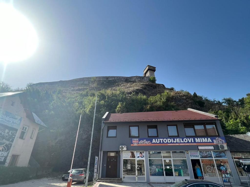 un edificio di fronte a una collina con una casa di stari grad a Doboj