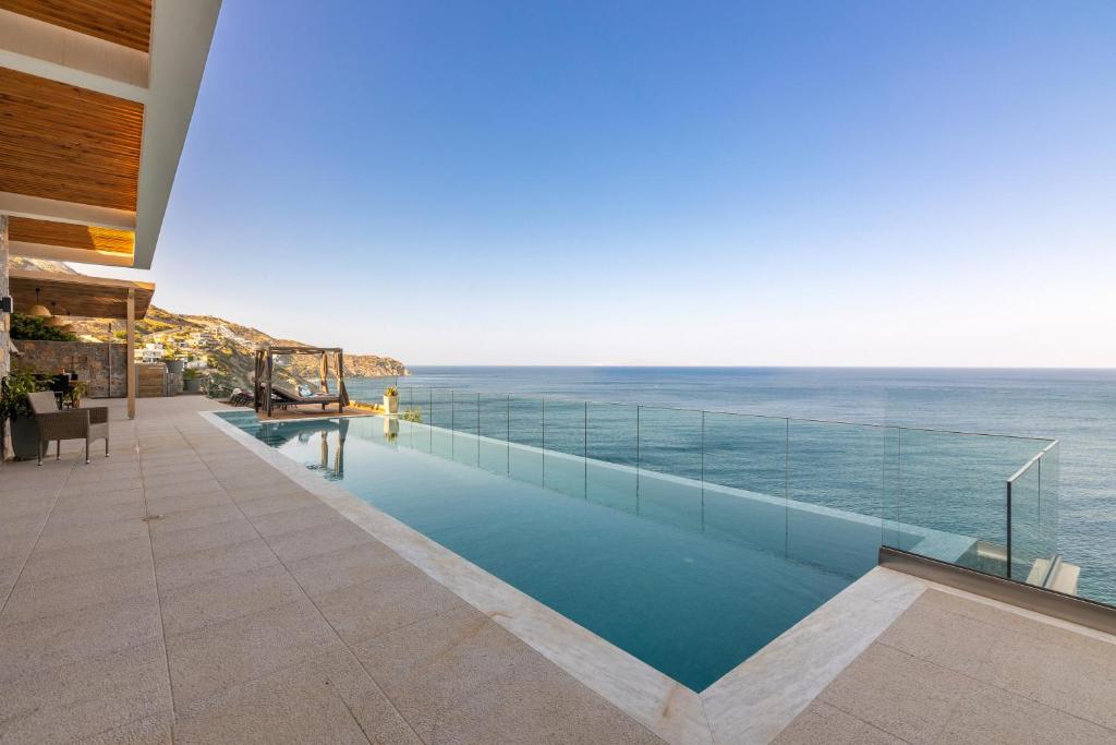 a swimming pool with a view of the ocean at Rocca al Mare Seaside Villas in Palaiokastro