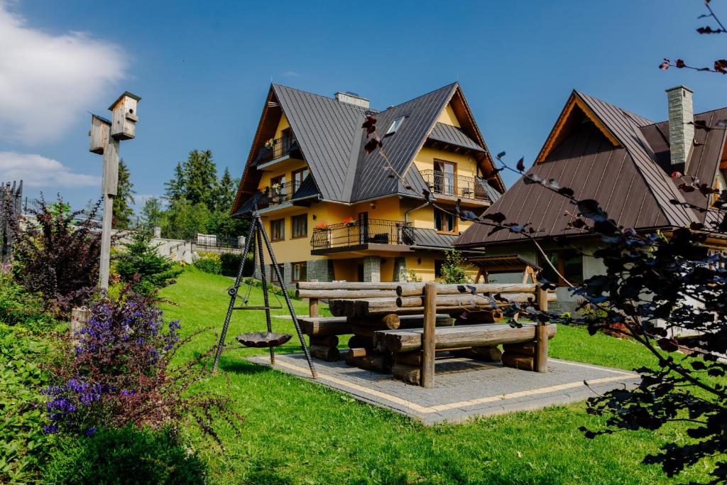 a large yellow house with a fence in front of it at Kwatery u Jacka in Groń