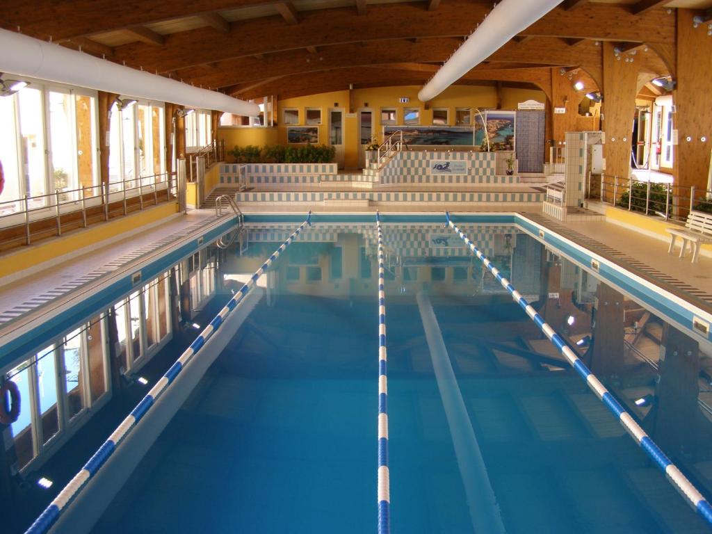 The swimming pool at or close to LE NEREIDI Hotel & Residence con Piscina-Tennis-Fitness-Parcheggio coperto-Sala Conferenze