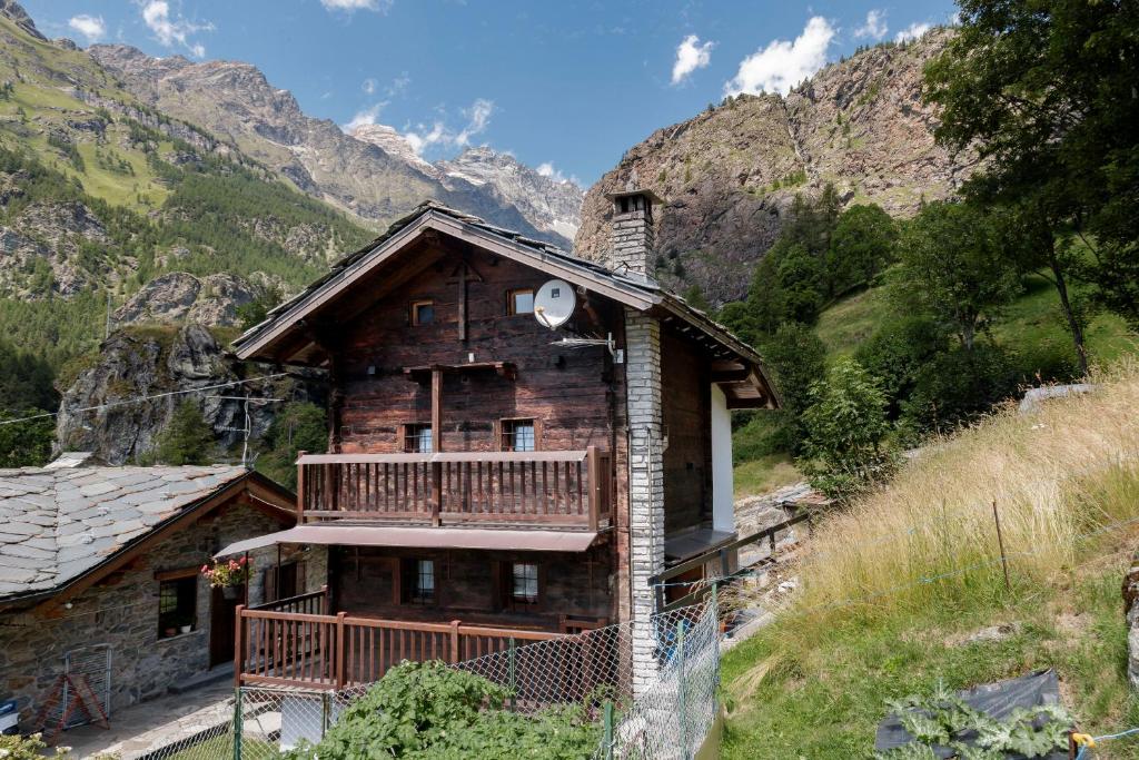 a log cabin in the mountains with a balcony at HelloChalet - Chalet Grené typical house with garden - 1km cabelcar in Valtournenche