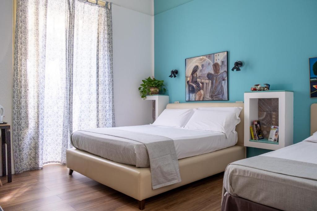 1 Schlafzimmer mit 2 Betten und blauen Wänden in der Unterkunft Ai Vicerè in Palermo