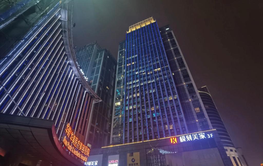 grupa wysokich budynków w mieście w nocy w obiekcie Doaland Lab Hotel, Wuyi Plaza Helong Stadium w mieście Changsha
