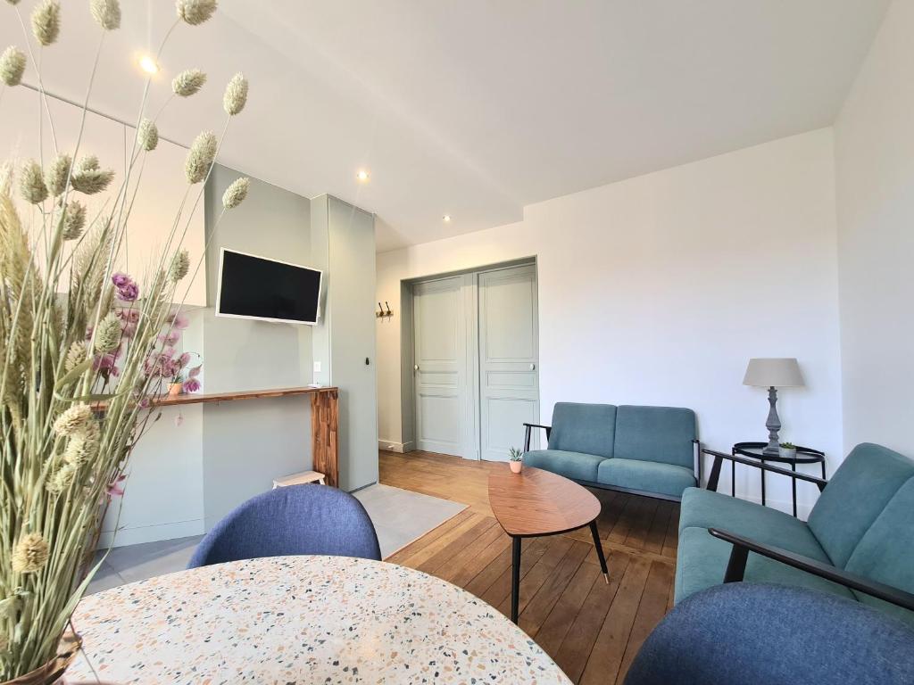 sala de estar con sillas azules y TV en Bel appartement F3 46m2 à 5' de Paris, en Ivry-sur-Seine