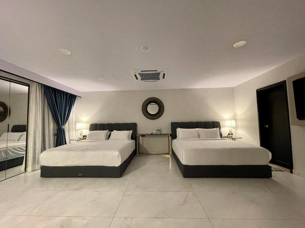 um quarto com duas camas e um relógio na parede em KLCC, Kuala Lumpur, Bukit Bintang at Times Square Hotel em Kuala Lumpur