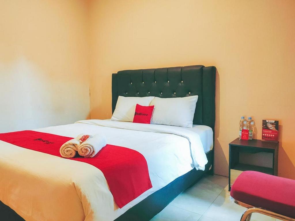 a bedroom with a bed with two towels on it at RedDoorz Syariah near Lippo Plaza Sidoarjo in Sidoarjo