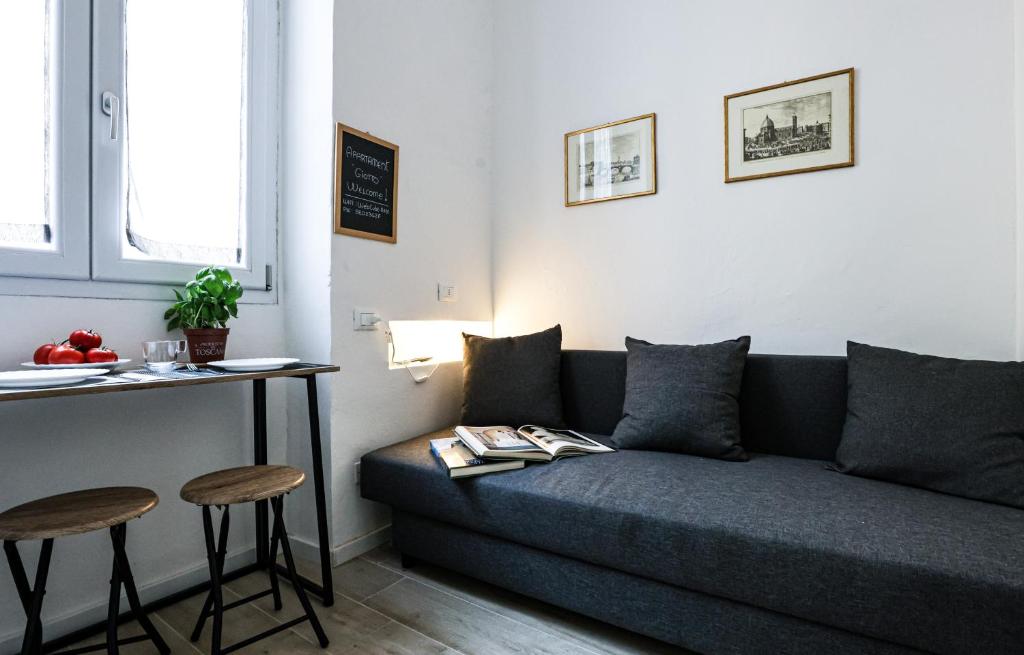 a living room with a couch and a table and stools at Giotto Studio Flat in Florence