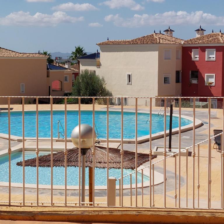 una piscina en un complejo con una valla en Apartamento con jardín en Altaona Golf en Murcia